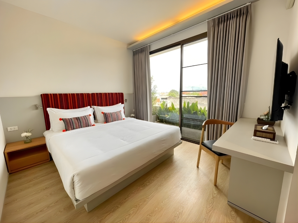 Giường ngủ đôi hướng ban công xanh mát tại Phòng Deluxe Đôi - Bích Động Hotel Ninh Bình