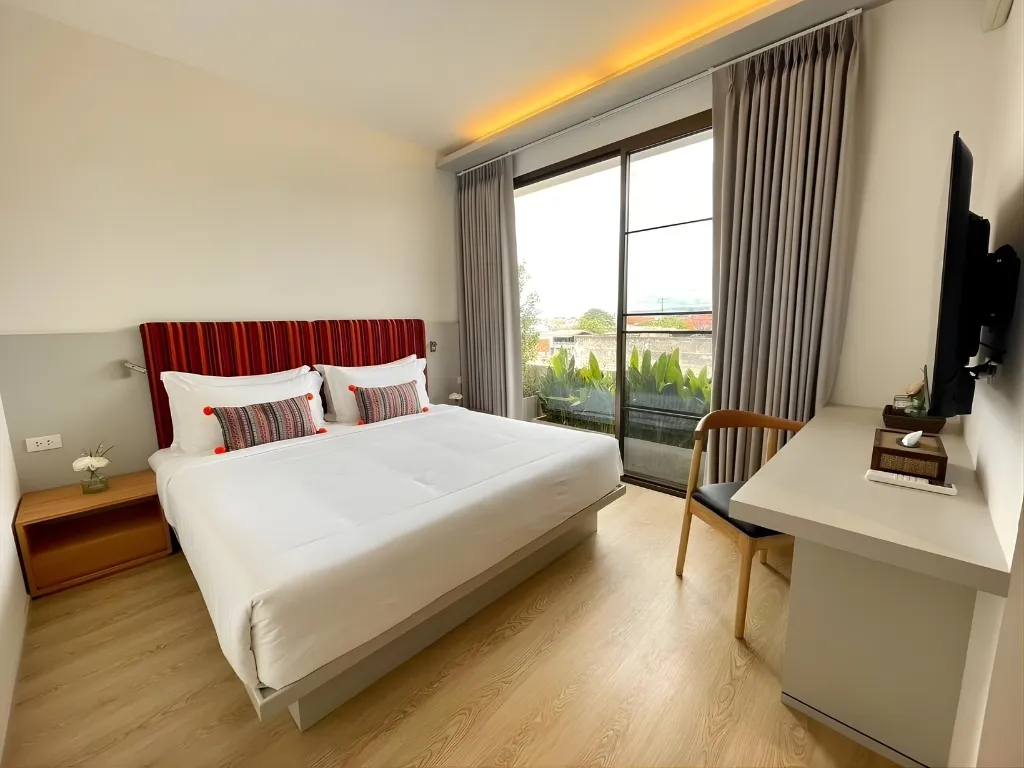 Giường ngủ đôi hướng ban công xanh mát tại Phòng Deluxe Đôi - Bích Động Hotel Ninh Bình