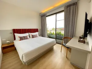 Giường ngủ đôi hướng tầm nhìn ra ban công xanh mát tại Bích Động Hotel